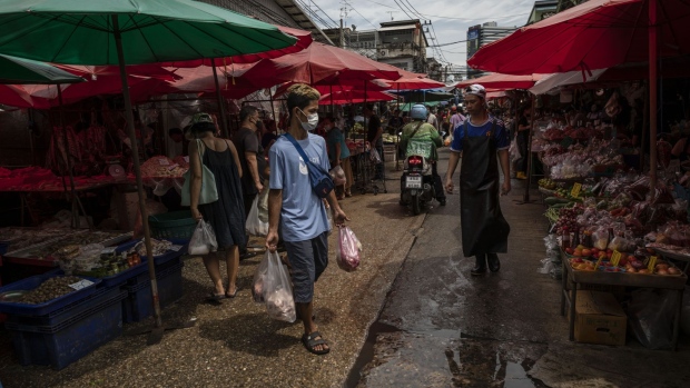 A man carries groceries through a wet market in Bangkok, Thailand, on July 2, 2022. Foreign tourist arrivals into Thailand are set to beat official forecasts with the lifting of pandemic-era restrictions, a rare positive for the nation’s Covid-battered economy and currency.
