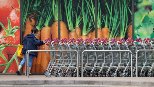 A customer retrieves a shopping trolley outside a J Sainsbury Plc supermarket in London, UK, on Friday, June 24, 2022. The Office for National Statistics said Friday the volume of goods sold in stores and online fell 0.5% in May, as soaring food prices forced consumers to cut back on spending in supermarkets.