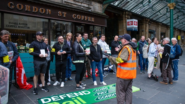 Striking workers at a National Union of Rail, Maritime and Transport Workers (RMT) picket line near Glasgow Central railway station in Glasgow, UK, on Tuesday, June 21, 2022. UK rail workers began Britain's biggest rail strike in three decades on Tuesday after unions rejected a last-minute offer from train companies, bringing services nationwide to a near standstill.