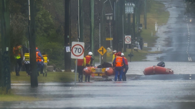 SYDNEY, AUSTRALIA - JULY 04: A family are evacuated by State Emergency Service workers due to rising floodwaters in Bligh Park on July 04, 2022 in Sydney, Australia. Thousands of residents were forced to leave their homes overnight and a number of evacuation orders are in place across Sydney as heavy rain and flooding continues. (Photo by Jenny Evans/Getty Images)