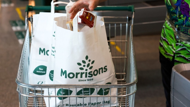 A customer places goods in to a paper bag at a Morrisons supermarket, operated by Wm Morrison Supermarkets Plc, in Saint Ives, U.K., on Monday, July 5, 2021. Apollo Global Management Inc. said Monday it's considering an offer for Morrison, heating up a takeover battle for the U.K. grocer.