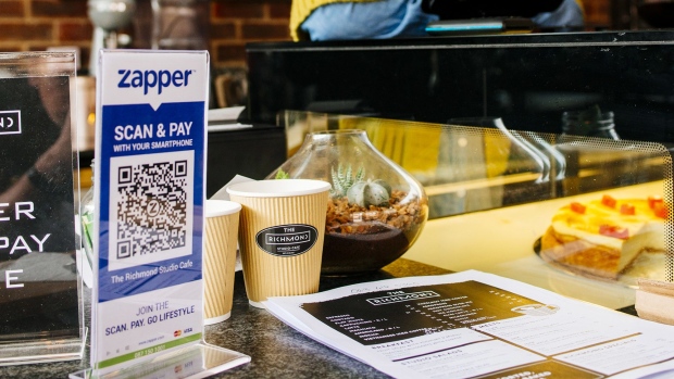 A Zapper 'Scan & Pay' QR code for mobile payment stands on the counter in a cafe in the Richmond district in Johannesburg.