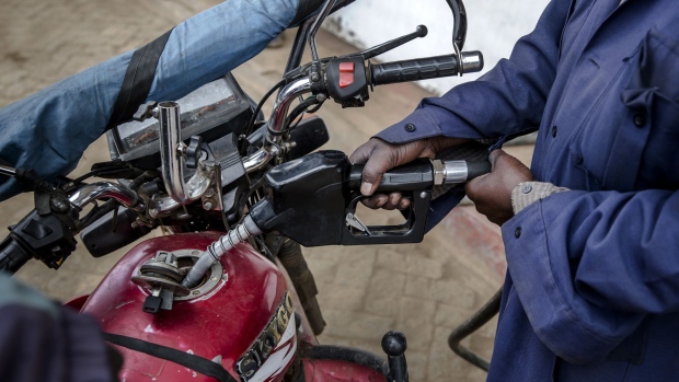 An attendant refuels a motorcycle taxi, known locally as a 'boda boda', at the Euro Petroleum petrol station in the Baba Dogo suburb of Nairobi, Kenya, on Wednesday, March 28, 2018. An impending 16 percent value-added tax on gasoline in Kenya will be passed on to consumers and increase inflation, practitioners told Bloomberg Tax. Photographer: Luis Tato/Bloomberg
