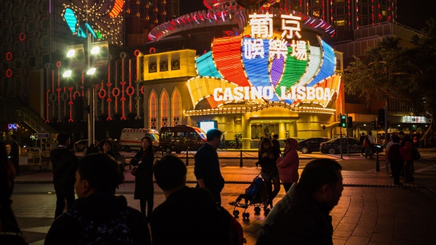 Buses wait at a traffic signal light next to Casino Grand Lisboa, operated by SJM Holdings Ltd., at night in Macau, China, on Tuesday, Feb. 4, 2020. Casinos in Macau, the Chinese territory that's the worlds biggest gambling hub, will close for 15 days as China tries to contain the spread of the deadly coronavirus.
