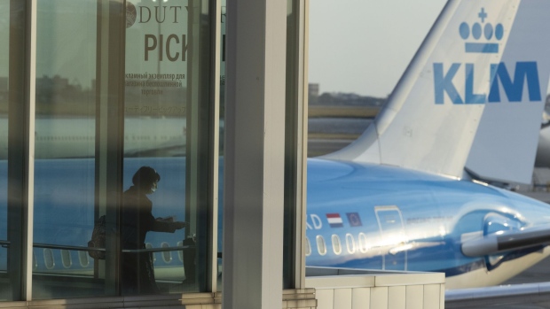 A passenger boards a KLM Royal Dutch Airlines flight to Amsterdam in Terminal 4 at John F. Kennedy International Airport (JFK) in New York, U.S., on Monday, Sept 27, 2021. The U.S. will soon allow entry to most foreign air travelers as long as they're fully vaccinated against Covid-19 -- while adding a testing requirement for unvaccinated Americans and barring entry for foreigners who haven't gotten shots.