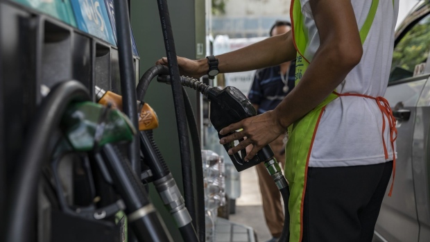 A gas station attendant removes a nozzle from a fuel pump at a gas station in Bangkok, Thailand, on July 2, 2022. Foreign tourist arrivals into Thailand are set to beat official forecasts with the lifting of pandemic-era restrictions, a rare positive for the nation’s Covid-battered economy and currency.