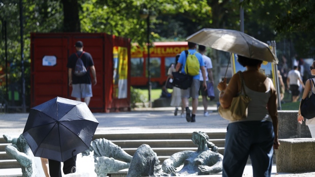 Pedestrians shelter from the sun under umbrellas during a heatwave in Frankfurt, Germany, on Thursday, July 25, 2019. Europe’s latest summer heatwave broke heat records just weeks after the continent recorded its hottest ever June, fueling concern that a shifting climate is making extreme weather events more frequent.