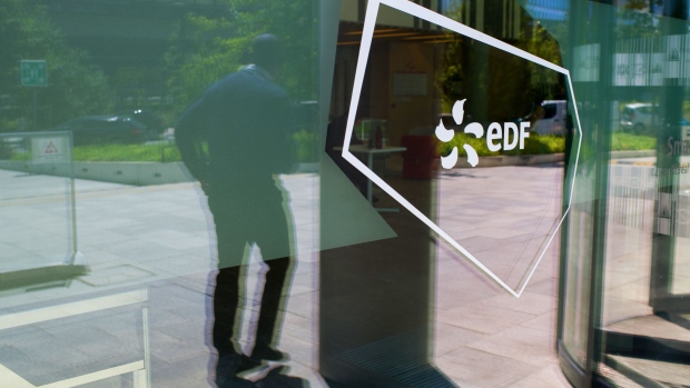 A logo in the window of the Electricite de France SA smartside campus in Saint Ouen, France, on Friday, July 8, 2022. The French government will nationalize its financially struggling nuclear giant Electricite de France SA to help it ride out Europe’s worst energy crisis in a generation and invest in new atomic plants.