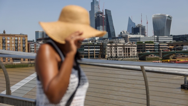 A pedestrian wearing a sunhat crosses the Millennium Bridge in London, UK, on Friday, June 17, 2022. UK temperatures may hit 34 degrees Celsius (93.2 degrees Fahrenheit) this week, a once-rare level that’s becoming more common on the back of global warming. Photographer: Hollie Adams/Bloomberg