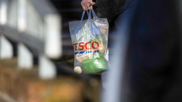 A customer carries a shopping bag outside a Tesco Plc supermarket in Chelmsford, U.K., on Wednesday, Jan. 12, 2022. U.K. retailers so far have largely been saying they fared well through the holiday season. Photographer: Chris Ratcliffe/Bloomberg