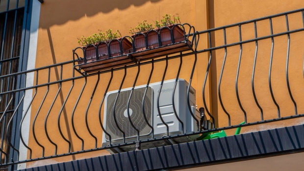 An air conditioning unit on the facade of a residential houses in Brescia, Italy, on Sunday, July 3, 2022. Italy's government plans further measures to cushion the impact of high energy prices, including extending a fuel tax holiday to the beginning of October, Il Messaggero newspaper reported. Photographer: Francesca Volpi/Bloomberg