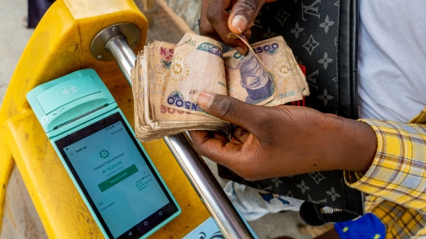 A mobile point of sale (POS) operator counts out Nigerian naira banknotes at Idumota market in Lagos, Nigeria, on Thursday, Jan. 6, 2022. Nigeria’s Lagos state government plans to build new roads, rail, housing, health, education and waterways infrastructure to boost businesses and improve living standards.