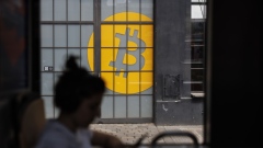 A passenger on a tram passes a Bitcoin logo on the doors of the venue of the Paralelni Polis project, an organisation combining art, social sciences and modern technology, in Prague, Czech Republic, on Tuesday, May 17, 2022. Crypto companies have started to plan for a potential protracted market slowdown. Photographer: Milan Jaros/Bloomberg