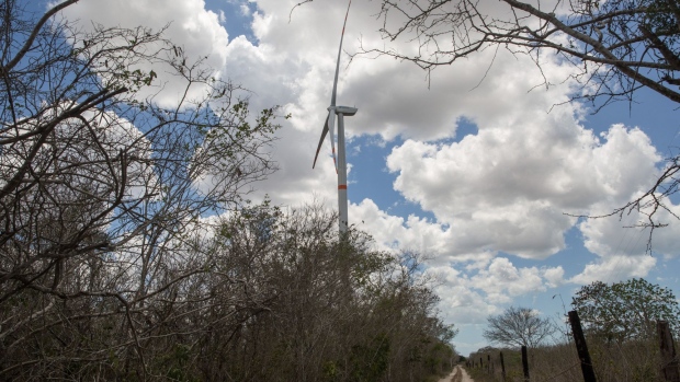 A wind turbine stands near a road in the town of Dzilam de Bravo near Merida, Yucatan, Mexico, on Saturday, May 19, 2018. At the end of the last century, before the commodities boom brought a wave of development to Latin America, opposition to the blight of new electricity infrastructure was rare. People just wanted the energy. Now that 100 percent of the region's biggest economies have access to power, the "Not in my backyard" movement—or Nimby'ism—that has long been the norm from Europe to the U.S. is creeping in here, too. Photographer: Brett Gundlock/Bloomberg