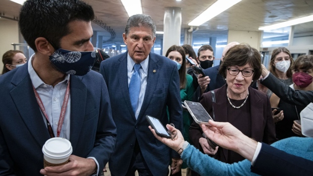 Senator Joe Manchin, a Democrat from West Virginia, center, and Senator Susan Collins, a Republican from Maine, right, speak to members of the media while arriving for a vote in Washington, D.C., U.S., on Thursday, Dec. 2, 2021. House Democrats released a bipartisan short-term spending bill to keep the government open after midnight Friday and plan to put it to a House vote later today.