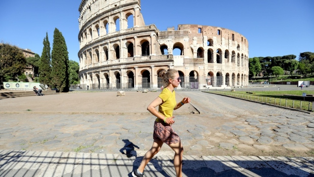 A jogger passes the Colosseum in Rome, Italy, on Monday, May 4, 2020. With Italy still in the throes of Europe's deadliest coronavirus outbreak, more than 4 million people are cleared to return to work on Monday.