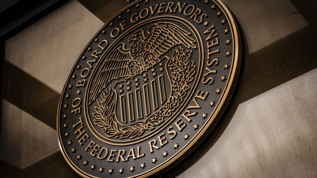 The seal of the U.S. Federal Reserve Board of Governors across the street from the Marriner S. Eccles Federal Reserve building in Washington, D.C., U.S., on Sunday, Dec. 19, 2021. The Federal Reserve chair has tempered his ambition to restore the labor market to its pre-pandemic strength, as the central bank confronts surging inflation and a workforce still constrained by Covid-19. Photographer: Samuel Corum/Bloomberg