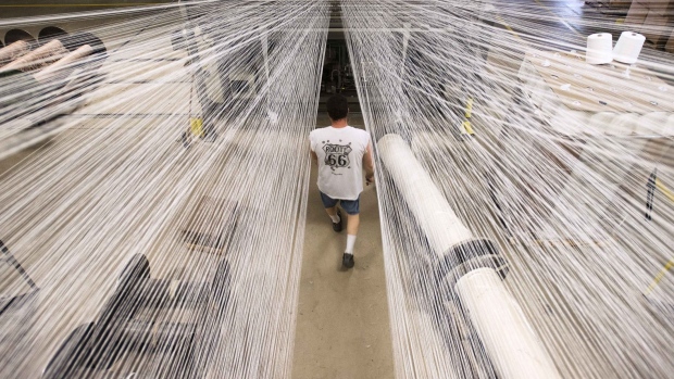 An employee loads up new rolls of material onto racks at a carpet manufacturing facility in Bloomsburg, Pennsylvania. Photographer: Ty Wright