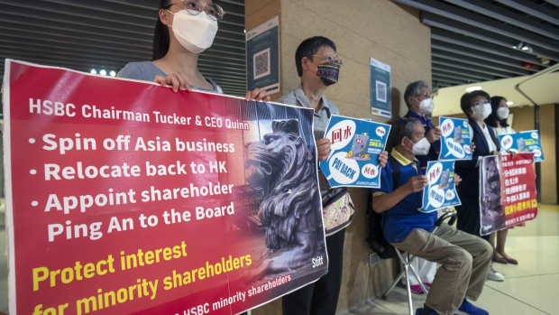 Investors hold placards ahead of an HSBC Holdings Plc informal shareholders meeting in Hong Kong, China, on Tuesday, Aug. 2, 2022. HSBC executives and directors is meeting investors today amid calls by Ping An Insurance Group Co., its largest shareholder, to split up the lender.