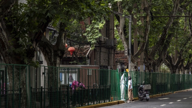 A pedestrian in front of fencing surrounding a residential neighborhood placed under lockdown due to Covid-19 in Shanghai, China, on Wednesday, July 6, 2022. Shanghai launched mass testing for Covid in nine districts after detecting cases the past two days, fueling concerns that China’s financial hub may once again find itself locked down in pursuit of Covid Zero. Photographer: Qilai Shen/Bloomberg