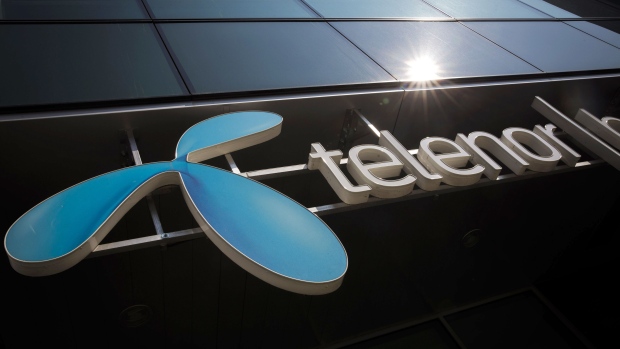 A sign sits on display outside a Telenor Banka AD bank branch, operated by Telenor ASA, in the 'Airport City' business quarter of Belgrade, Serbia, on Wednesday, March 28, 2018. Telenor ASA agreed to sell its businesses in central and eastern Europe to Czech billionaire Petr Kellner’s investment firm PPF Group for 2.8 billion euros ($3.4 billion) as the Norwegian phone company focuses on markets in Asia and Scandinavia. Photographer: Oliver Bunic/Bloomberg