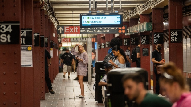 Commuters wait on the platform of a subway station in New York.