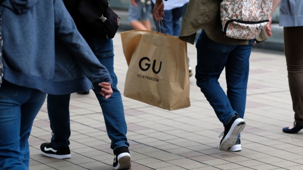 A shopper carrying a GU shopping bag in Kawasaki.