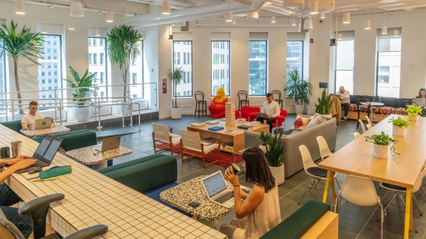 Members work in the cafeteria at the WeWork Cos Inc. 85 Broad Street offices in the Manhattan borough of New York, U.S., on Wednesday, May 22, 2019. WeWork has become the biggest private office tenant in London, Manhattan and Washington on its way to 425 office locations in 36 countries overall.