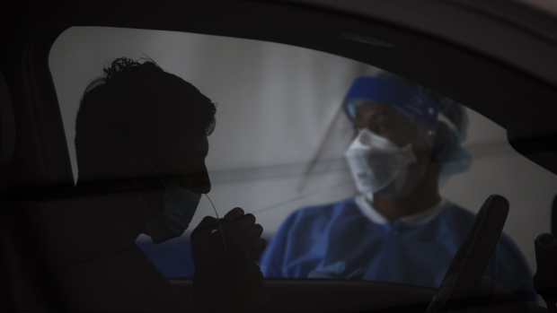 A resident takes a Covid-19 swab test at a drive-thru testing site outside the Southwest Multi-Service Center in Houston, Texas, U.S., on Wednesday, Aug. 4, 2021. U.S. President Joe Biden singled out Florida and Texas, where cases are surging, criticizing the pandemic response by the governors in those states. The two states are responsible for about one-third of all new cases in the U.S. in the past week, the administration said Monday. Photographer: Mark Felix/Bloomberg