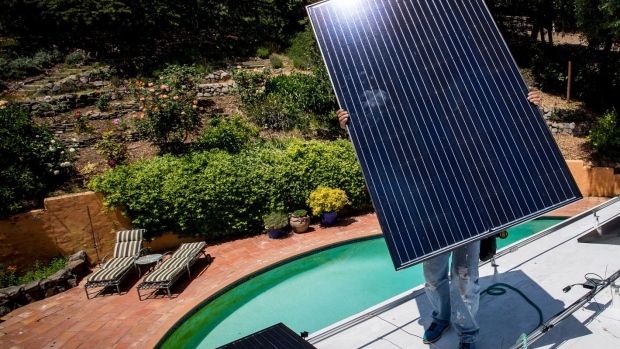 A worker installs solar panels on the roof of a home in Lafayette, California.