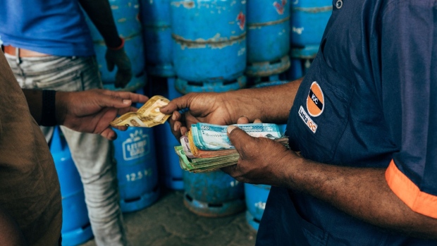 A clerk hands changes at the Pellawatte Litro Gas filling station in Colombo, Sri Lanka, on Sunday, May 22, 2022. Sri Lanka’s dollar bonds due July rebound after Friday’s drop, up almost 5 cents on the dollar in the biggest gain since October, as the government holds bailout talks with the IMF. Photographer: Jonathan Wijayaratne/Bloomberg