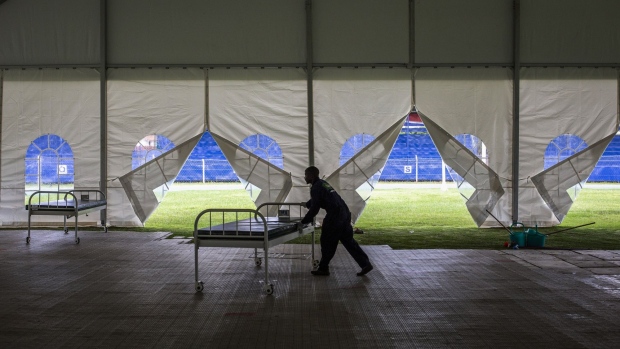 A worker pushes a trolley bed into position at the Machakos County Field Hospital near Nairobi, Kenya, on Monday, May 4, 2020. Kenya is exploring debt-relief options with lenders and considering a proposal by an industry body to freeze interest payments on pension assets, as the state seeks more money to deal with the coronavirus pandemic. Photographer: Patrick Meinhardt/Bloomberg