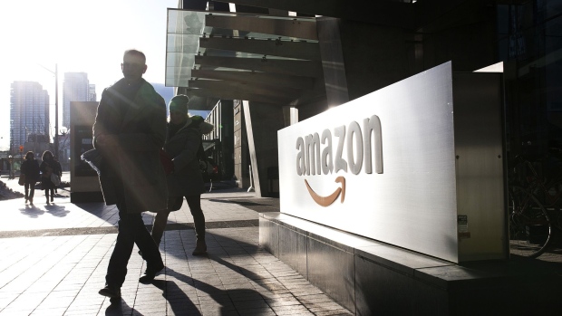 Pedestrians walks past Amazon.com Inc. headquarters in the financial district of Toronto, Ontario, Canada, on Friday, Feb. 21, 2020. Canadian stocks declined with global markets, as authorities struggled to keep the coronavirus from spreading more widely outside China. However, investors flocking to safe havens such as gold offset the sell-off in Canada's stock market. Photographer: Stephanie Foden/Bloomberg