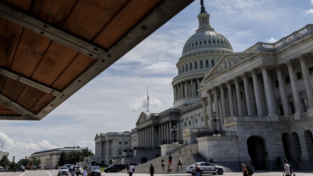 Pedestrians walk past the US Capitol building in Washington, D.C., US, On Saturday, Aug. 6, 2022. The Senate is in for a rare weekend session as Democrats look to pass their tax, climate, and drug-pricing bill through the budget reconciliation process. Photographer: Ting Shen/Bloomberg