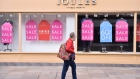 WORCESTER-ENGLAND - MARCH 27: A lady wearing a mask walks past a closed Joules shop in Worcester Town Center on March 27, 2021 in Worcester, England . (Photo by Nathan Stirk/Getty Images)