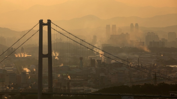Smoke billows from an industrial complex beyond the Ulsan Harbor Bridge at dusk in Ulsan, South Korea, on Sunday, Aug. 4, 2019. Ulsan is known as Hyundai Town, an industrial powerhouse with the world’s largest car-assembly plant, its third-biggest oil refinery and the giant shipyards. Since 2016, some 35,000 workers quit or lost their jobs at the city's shipyard, in a downturn as dramatic as it was sudden.