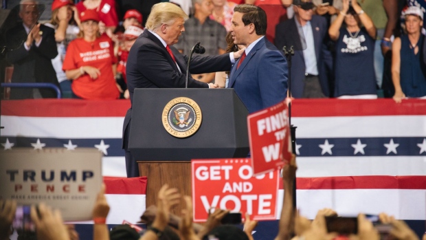 Ron DeSantis, governor of Florida, center, speaks during a U.S. President Donald Trump 'Homecoming' rally in Sunrise, Florida, U.S., on Tuesday, Nov. 26, 2019. Trump is preparing to pour hundreds of millions of dollars into Florida for his 2020 campaign after changes in demographics and voting laws put the linchpin swing state up for grabs. Photographer: Jayme Gershen/Bloomberg
