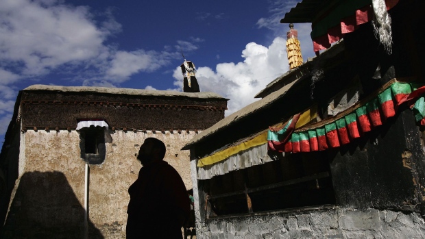SHIGATSE, CHINA - AUGUST 30: (CHINA OUT) A monk looks on at the Tashilhunpo Monastery on August 30, 2006 in Shigatse of Tibet Autonomous Region, China. Chinese tourists are flooding into Tibet this summer with the recently completed Qinghai-Tibet railway bringing an extra 3,000 people a day into Tibet. Critics say that it could threaten the cultural and even the physical landscape of the fragile Tibetan plateau and accelerate Lhasa's changing face as it continues to expand into a modern Chinese city. Expensive hotels and shops have opened in the new section of Lhasa while the Tibetan quarter fights to hold onto its cultural image, according to reports. (Photo by China Photos/Getty Images)