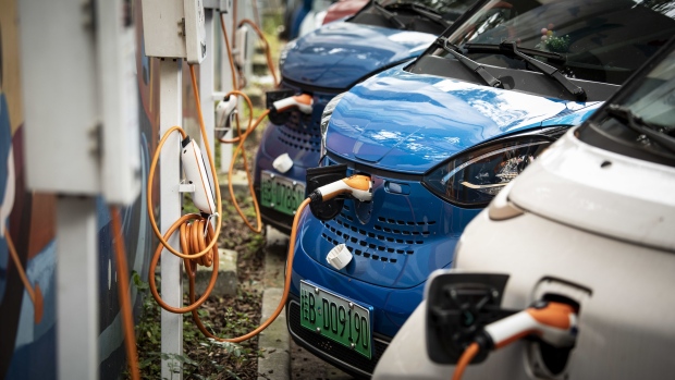 SAIC-GM-Wuling Automobile Co. electric vehicles are plugged in at charging stations at a roadside parking lot in Liuzhou, China, on Monday, May 17, 2021. Liuzhou has used test drives, free parking and abundant charging points to get people to embrace EVs. Photographer: Qilai Shen/Bloomberg