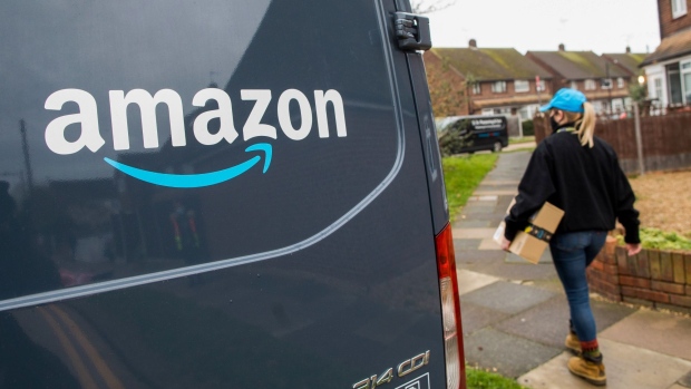 An Amazon.com Inc. delivery driver carries a customer order on a residential street in Westcliff-on-Sea, U.K., on Thursday, Nov. 26, 2020. With Black Friday almost underway, equity traders are bracing for a holiday season where brick-and-mortar businesses that lack strong digital platforms could suffer.