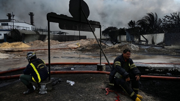 Firefighters rest in the area where the massive fire at a fuel depot sparked by a lightning strike occurred in Matanzas, Cuba, on August 9, 2022.  Photographer: Yamil Lage/AFP/Getty Images