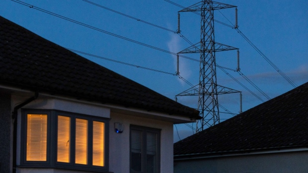 A light on at a residential home near an electricity transmission tower in Upminster, UK, on Monday, July 4, 2022. The UK is set to water down one of its key climate change policies as it battles soaring energy prices that have contributed to a cost-of-living crisis for millions of consumers. Photographer: Chris Ratcliffe/Bloomberg