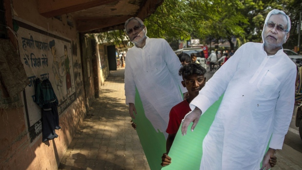 Supporters carry a cardboard cut-out of Bihar Chief Minister Nitish Kumar after a Bharatiya Janata Party (BJP) election rally featuring India Prime Minister Narendra Modi in Gaya, Bihar, India, on Friday, Oct. 23, 2020. Maintaining control of Bihar, a state with more people than any country in the European Union, is crucial for Modi's