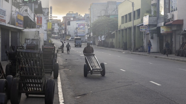 A worker with an empty two-wheeled cart makes his way to a wholesale market to find jobs in Colombo, Sri Lanka, on Tuesday, Aug. 9, 2022. Sri Lanka’s new President Ranil Wickremesinghe this month called on lawmakers and citizens to support his administration’s reform measures to help pull the nation out of its economic tailspin and negotiate a bailout program from the International Monetary Fund.