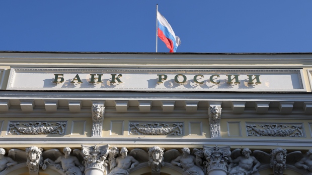 A Russian national flag above the headquarters of Bank Rossii, Russia's central bank, in Moscow, Russia, on Monday, Feb. 28, 2022. The Bank of Russia acted quickly to shield the nation’s $1.5 trillion economy from sweeping sanctions that hit key banks, pushed the ruble to a record low and left President Vladimir Putin unable to access much of his war chest of more than $640 billion. Photographer: Andrey Rudakov/Bloomberg