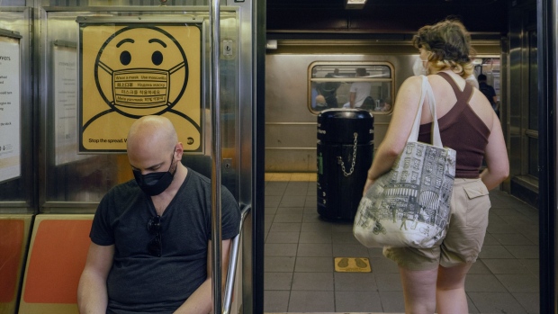 A sign notifies commuters to wear a mask inside a subway in New York, US, on Sunday, May 22, 2022. New York City has raised its Covid-19 alert level to high amid increasing pressure on the health care system.