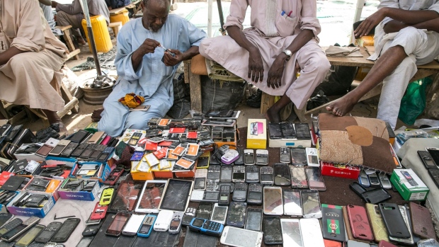 Street vendors display used mobile phone handsets for sale at Jagwal Electronics Market in Maiduguri, Nigeria, on Wednesday, May 1, 2019. Nigeria will propose a supplementary budget later this year to boost capital spending and fund a 67 percent increase in the minimum wage as government revenues improve, Budget Minister Udo Udoma said.