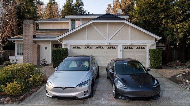 Tesla Inc. Model X and Model 3 cars sit parked in the driveway of a home with a Tesla Solar Roof in San Ramon, California, U.S., on Saturday, Feb. 8, 2020. Tesla Chief Executive Officer Elon Musk is pushing the Solar Roof and batteries as essential components of the company's drive to reduce fossil fuel use.