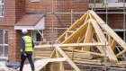 A builder passes roof trusses stored on a residential property construction site in Surrey, U.K. on Tuesday, Feb. 8, 2022. The housing market has defied the plight of the wider economy since the pandemic began, boosted by temporary tax incentives, a shortage of stock and demand for properties outside urban areas with room to work from home. Photographer: Jason Alden/Bloomberg