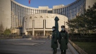 People's Liberation Army soldiers stand in front of the People's Bank of China (PBOC) in Beijing, China, on Monday, Dec. 13, 2021. Economists predict China will start adding fiscal stimulus in early 2022 after the country’s top officials said their key goals for the coming year include counteracting growth pressures and stabilizing the economy. Photographer: Andrea Verdelli/Bloomberg